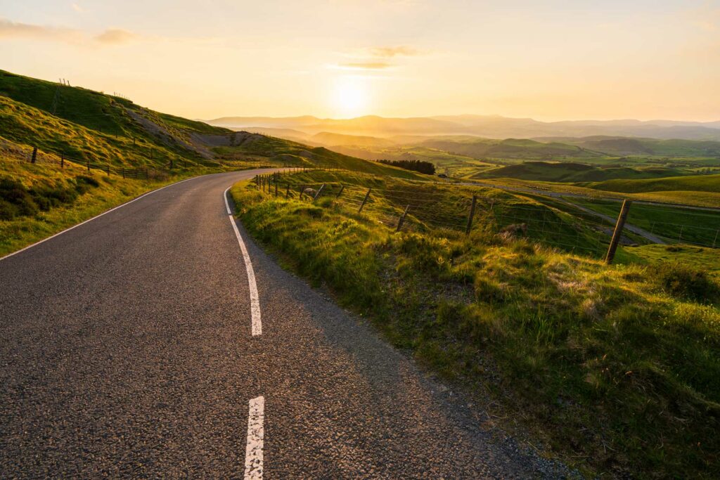 Scenic road with hills and sunset
