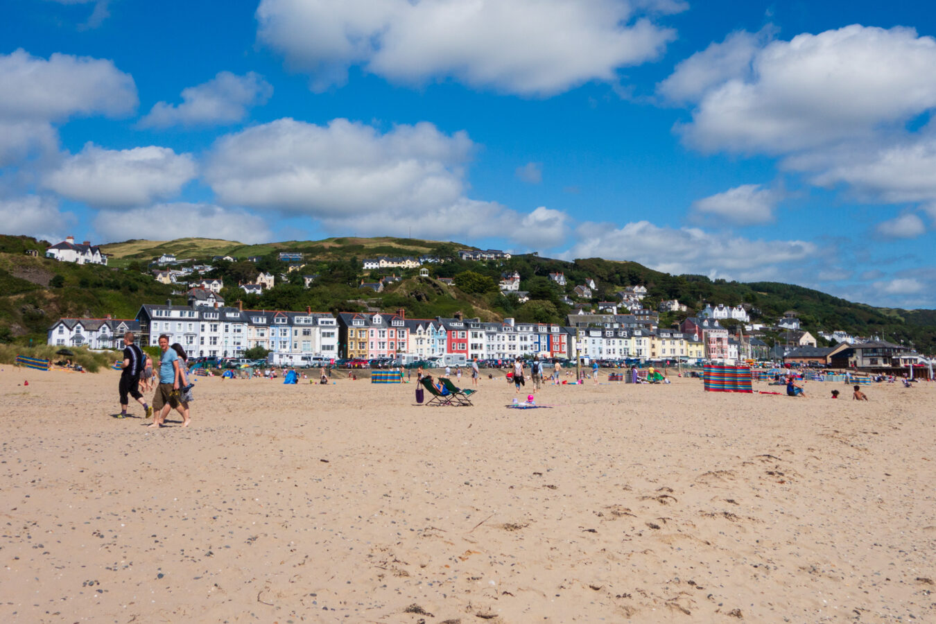Aberdyfi beach with coloured houses and hill in the background