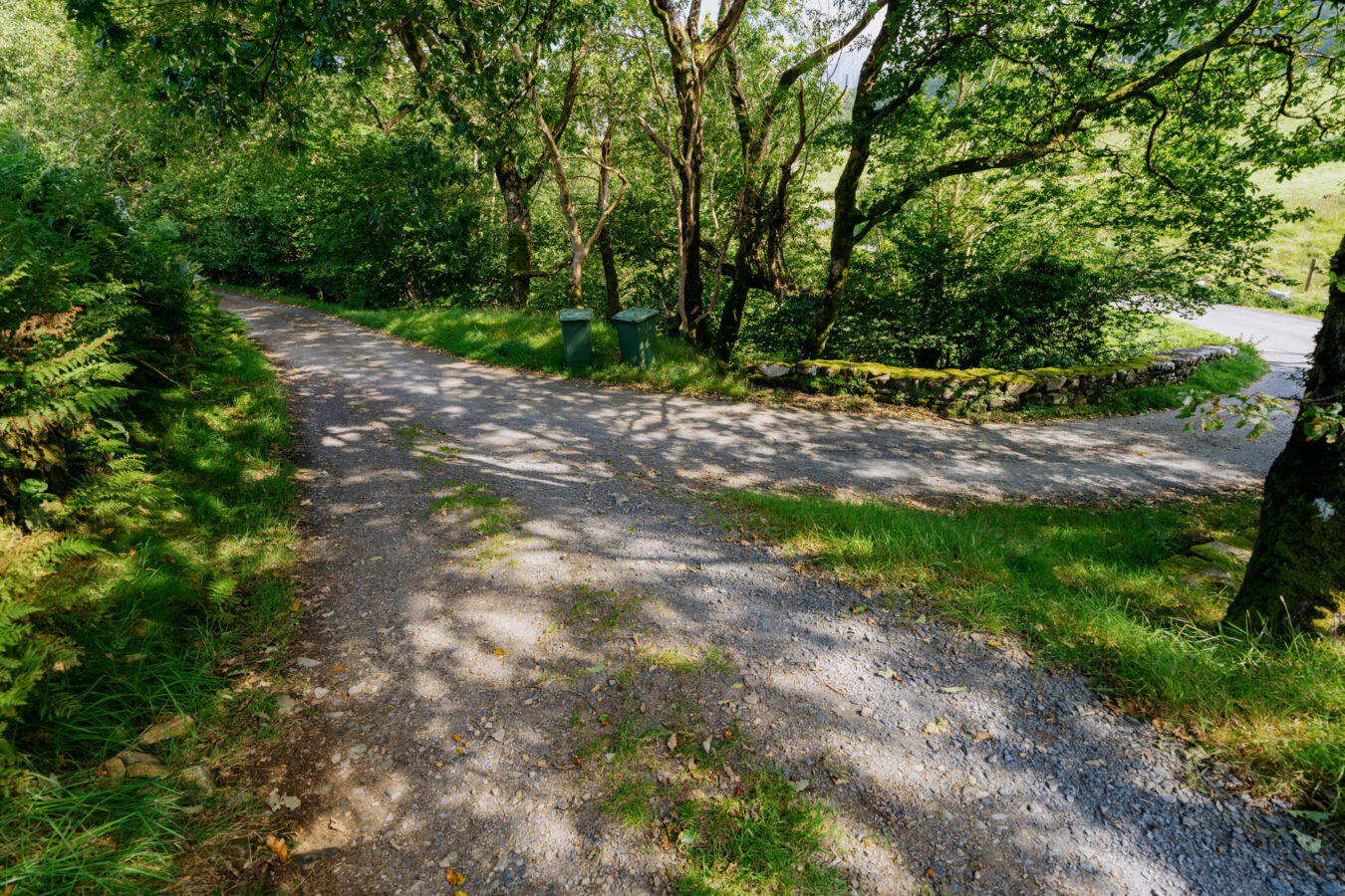 Farm track joins a paved road.