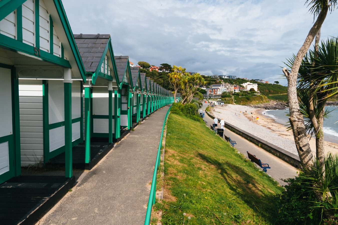 Green and white beach huts at Langland Bay