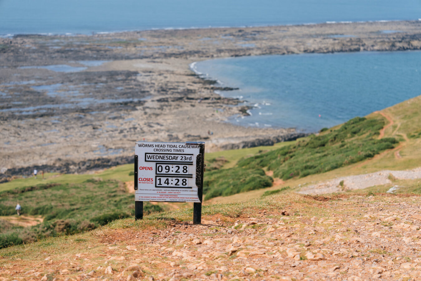 Sign with tide times at the beginning of the path to Worm's Head