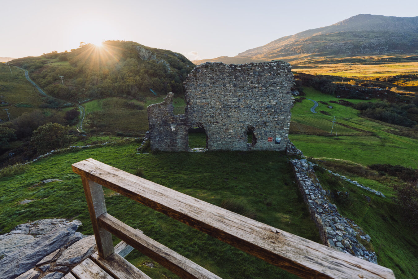 Ruins of Castell Dolwyddelan with sun setting behind the hill