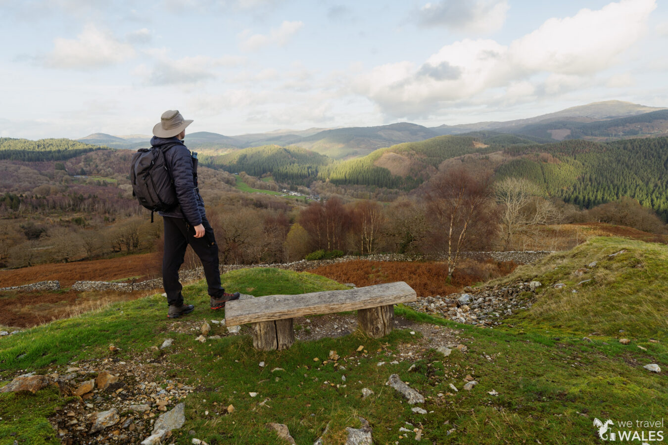 Man looking at panorama with hills and clouds