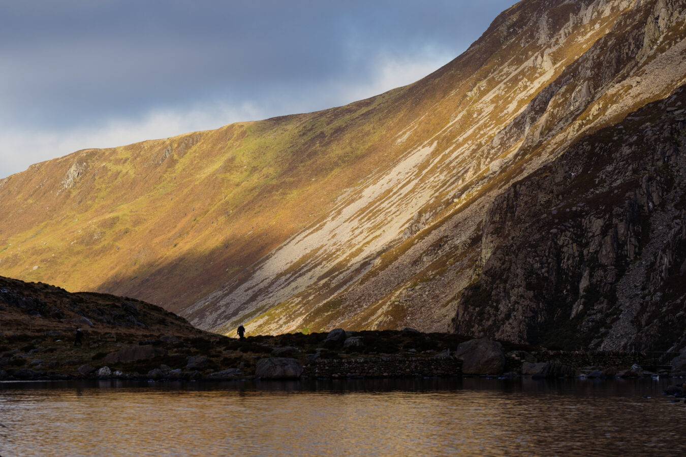 Llyn Idwal with mountains lit by sunshine in the background